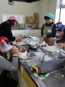 クリスマスケーキのデコレーションを楽しむ参加者