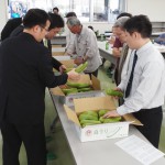 査定品を確認する生産者と市場担当者