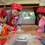 米粉ですいとんを作る女性部員と園児