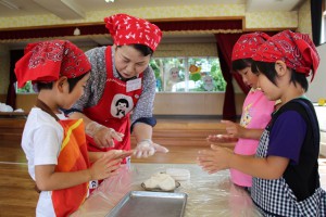 米粉ですいとんを作る女性部員と園児