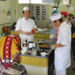 麻婆豆腐をおいしくつくるポイントを説明する千脇シェフ（左）