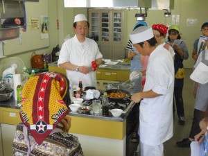 麻婆豆腐をおいしくつくるポイントを説明する千脇シェフ（左）