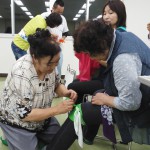 風呂敷を使った応急処置の方法を実践する女性部員