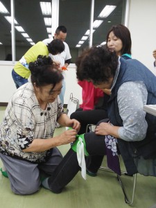 風呂敷を使った応急処置の方法を実践する女性部員