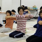 講師の説明に合わせて腕を伸ばす女性部員