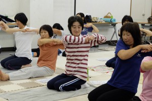 講師の説明に合わせて腕を伸ばす女性部員