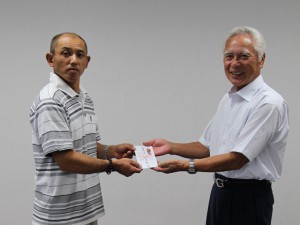 寄付金を贈呈する石毛会長（左）