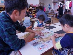 脱穀に挑戦する園児と青年部員