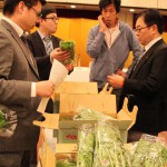 出荷規格を確認する生産者と市場担当者