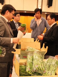 出荷規格を確認する生産者と市場担当者