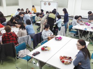 クリスマスリースを作る参加者たち