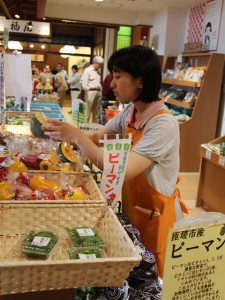 「みどりの大地」で商品の整理をする新入社員の大島さん