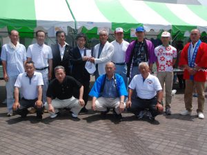 寄付を手渡す長島正会長（後列・左から5人目）          (7月3日)