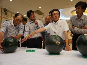 査定品を確認する生産者と市場関係者