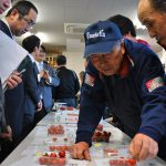 査定品を確認する生産者と市場担当者(