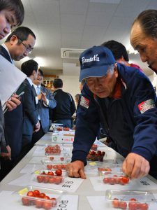 査定品を確認する生産者と市場担当者(