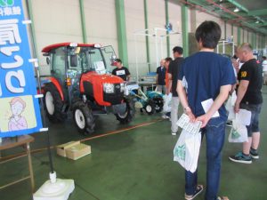 展示された農機具に興味を持つ来場者たち(7月12日)