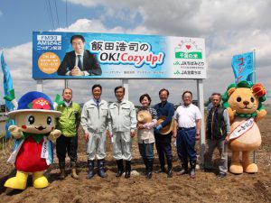 田植えに参加した同ＪＡ間渕組合長（左から3番目）と飯田アナウンサー（左から5番目）新行アナウンサー（左から４番目）ら（4月26日