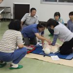 救命救急士の指導のもと心肺蘇生を行う女性部員ら(7月9日)