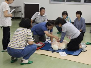 救命救急士の指導のもと心肺蘇生を行う女性部員ら(7月9日)