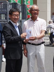 寄付を手渡す長島会長(右)(7月1日)