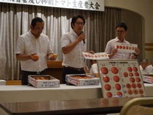 生産者に呼びかける市場担当者(9月7日)