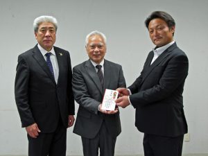 寄附金を贈呈する宇野澤会長（右）（11月13日