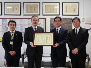 賞状を石見校長(左から2番目)に手渡す向後専務(2月5日)