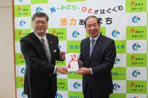 「粒すけ」を贈呈する向後常務（左）（匝瑳市）
