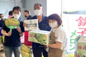 メロンを受け取る当選者（右）（6月13日）